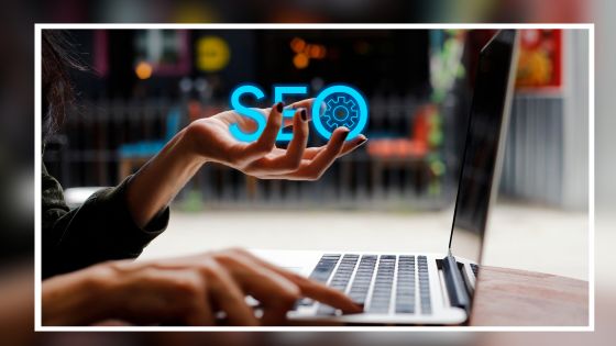 Person on a computer holding the letters SEO.
