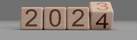 Four wooden cubes show the numbers 2 0 2 and the final cube is changing from 3 to 4 representing the change from 2023 to 2024.